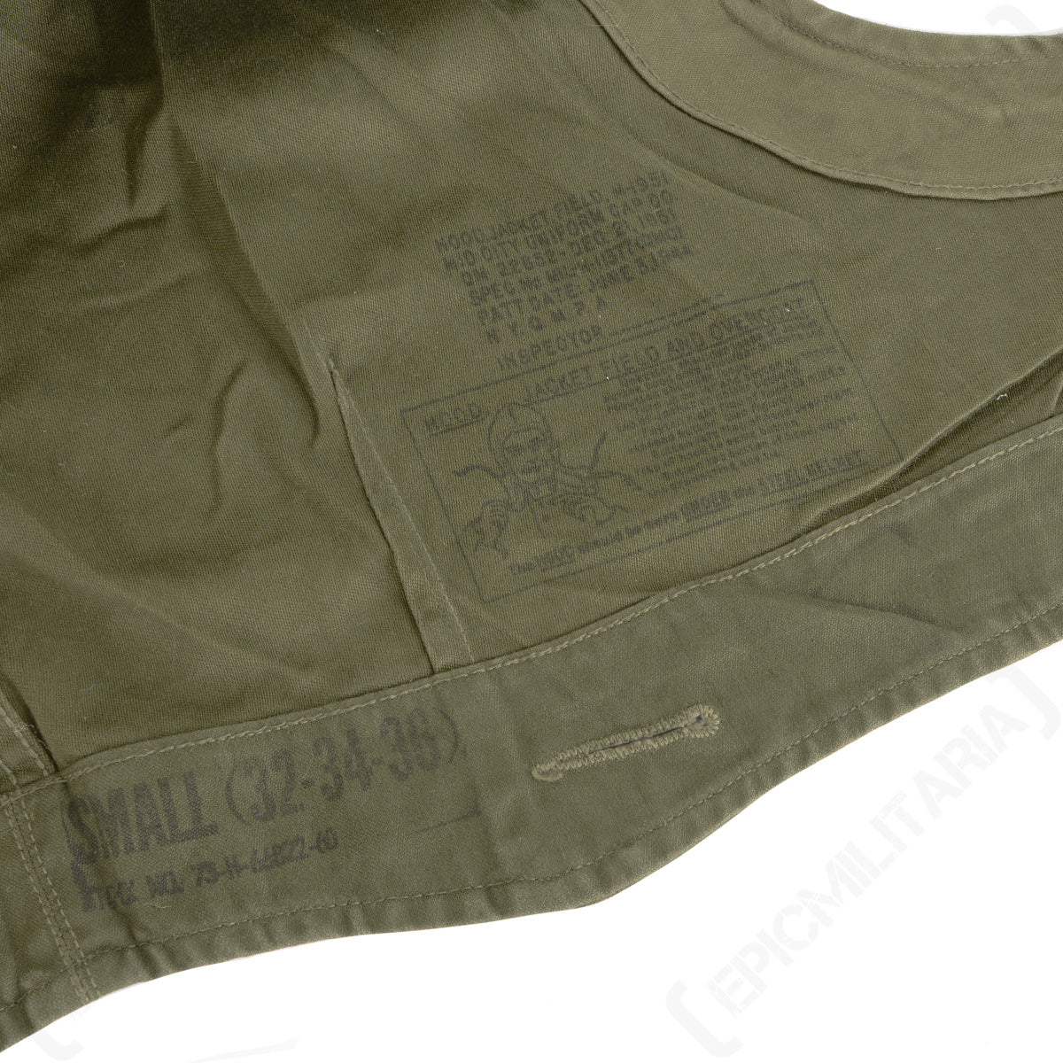 Close-up of the interior of an original M43 hood, displaying stamped military markings including size Small 32-34-36 and stock number details.