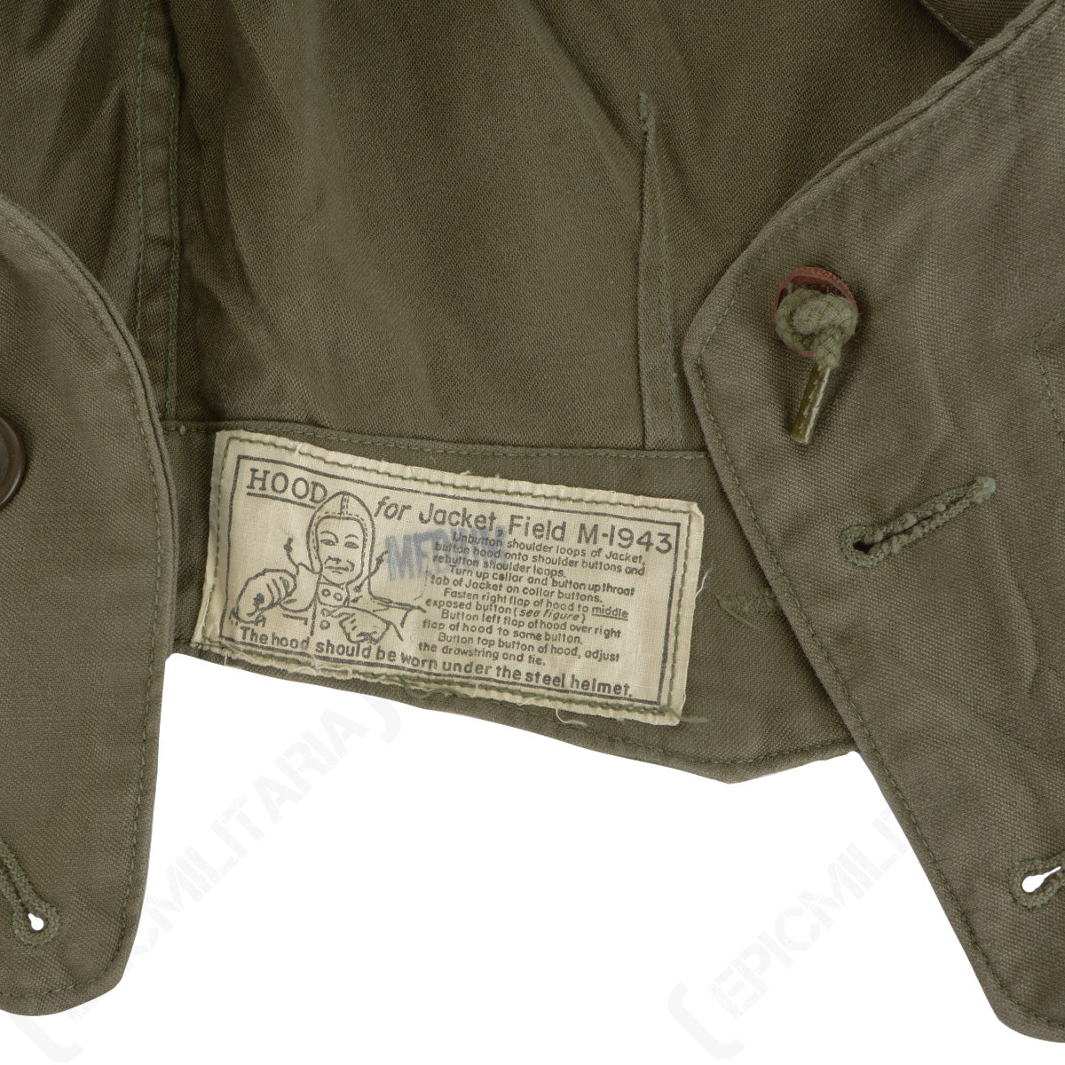 Close-up of the official WWII US Army M43 field jacket hood laundry tag with original printed instructions and military branding.