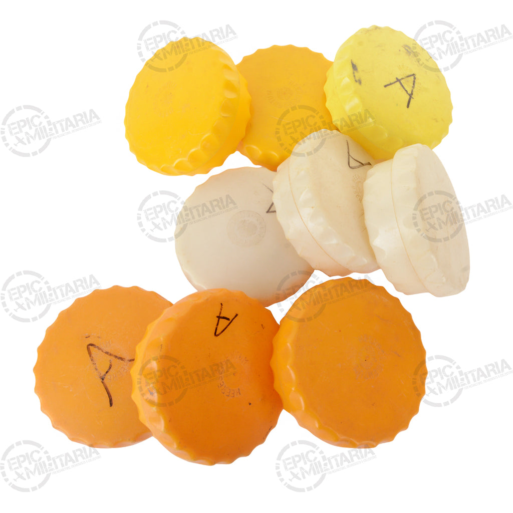 Group of vintage Austrian Army butter dishes in multiple colors, some lids marked with handwritten characters for historical character.