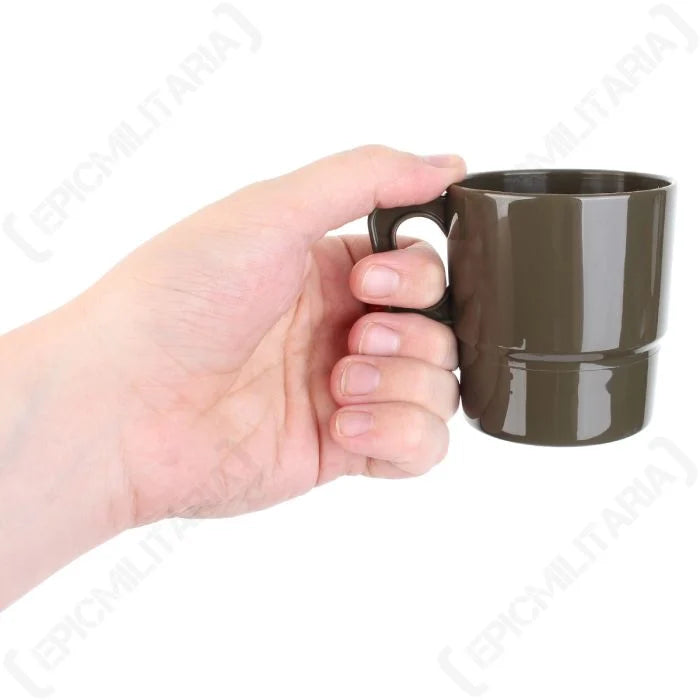 Olive drab plastic camping mug with handle held in hand