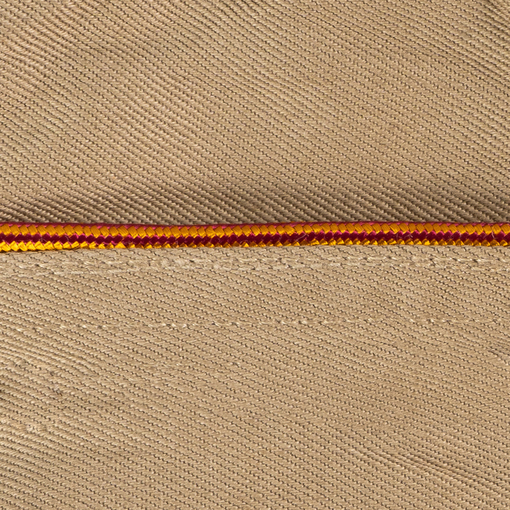 Macro shot of two-tone burgundy and yellow braided piping detail on a collector's US Army Garrison Cap.