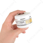 Hand holding compact 40ml tub of black Duckswax leather wax