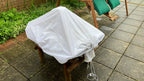 A garden stool covered with a white waterproof utility sheet, secured tightly with the adjustable cord and toggle.