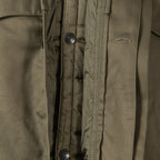 Detail of the internal popper button fastening system for the quilted liner inside the parka.