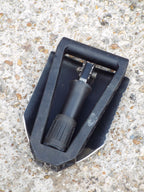 Compact folded Gerber E-Tool for easy transport, showing the serrated steel shovel blade and secure locking handle.