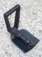 Gerber folding shovel positioned in hoe configuration, highlighting the serrated blade edge and 3-way folding design.
