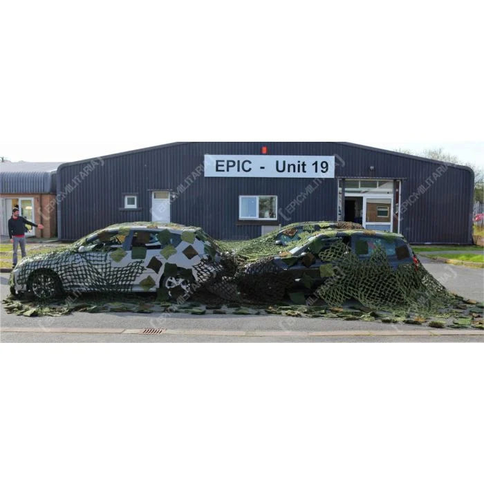 Large Czech Army camouflage net covering four cars in a car park
