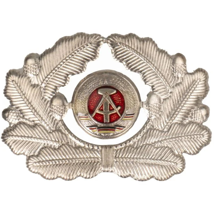 Front view of original East German NVA officers cap badge showing silver oak leaf wreath and DDR national emblem