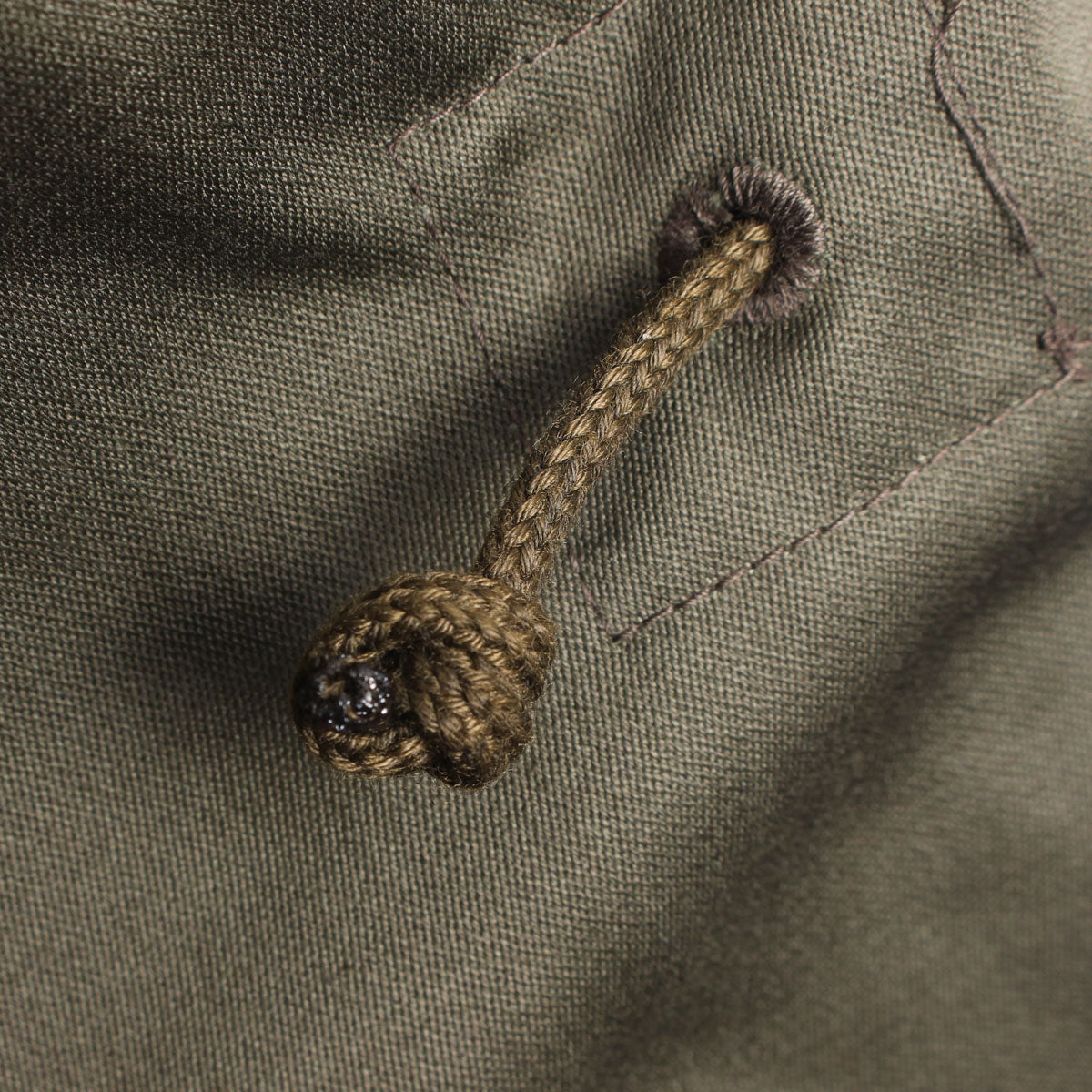 Detail of the durable fabric drawcord used for adjusting the waist of the field jacket.