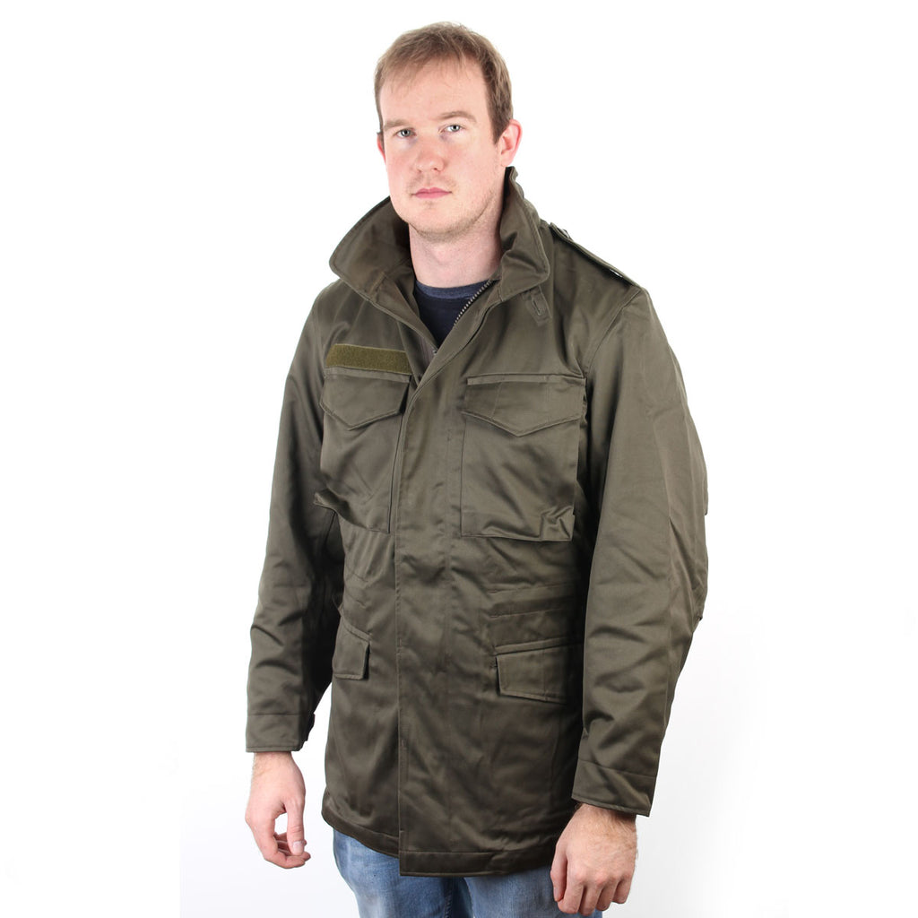 Man wearing a genuine Austrian Army M65 olive drab parka with a high collar and cargo pockets.