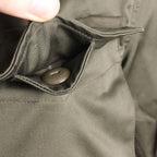 Interior view of a spacious cargo pocket on the Austrian military field jacket, showing the buttoned security flap.