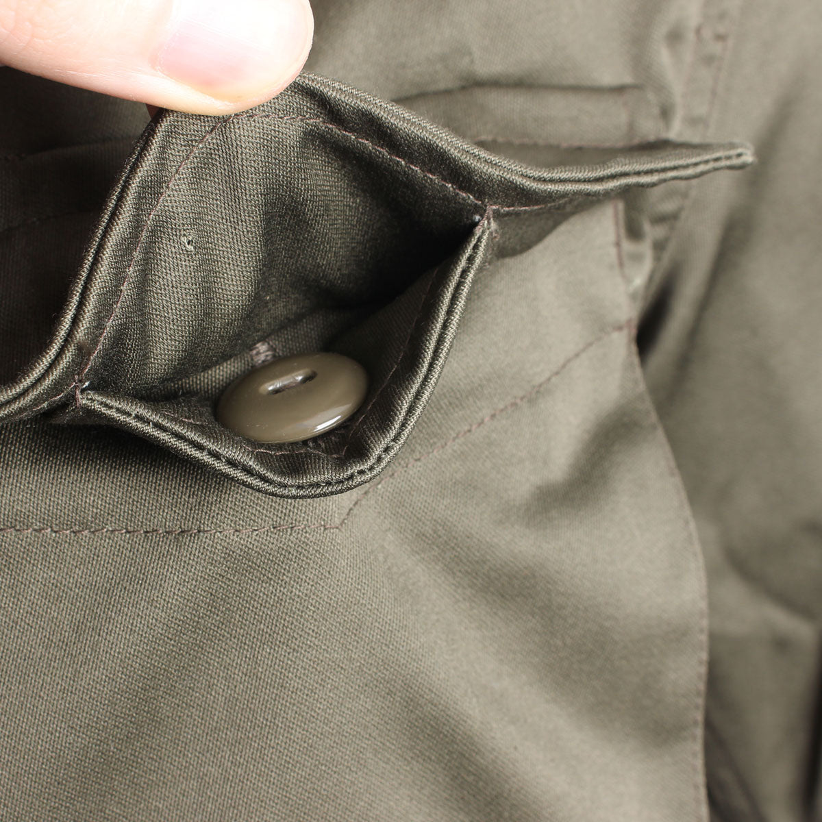 Interior view of a spacious cargo pocket on the Austrian military field jacket, showing the buttoned security flap.