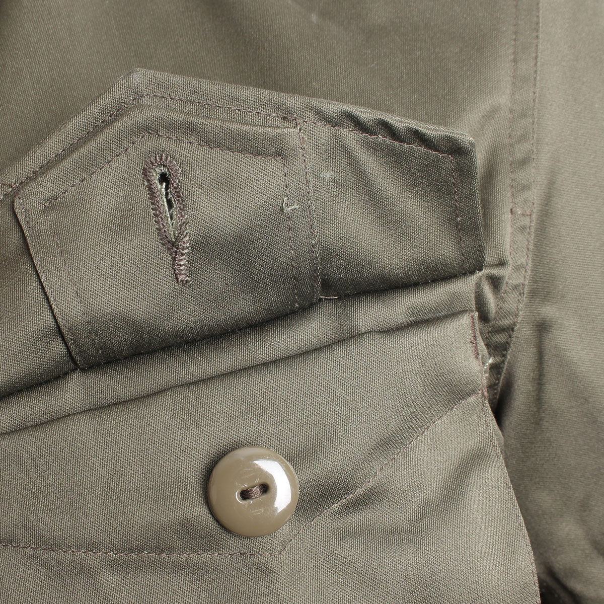 Close-up of a front cargo pocket flap featuring the signature button-down design to prevent snagging.