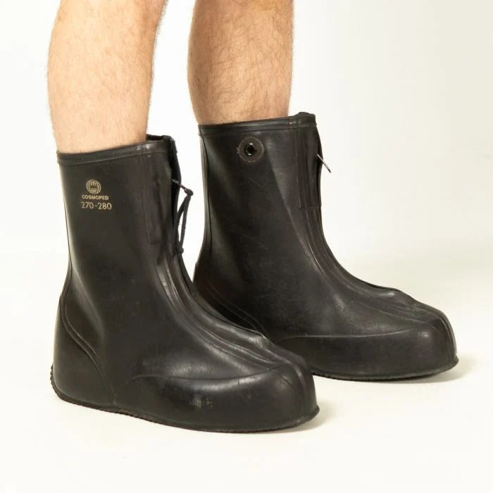 German Army rubber overboots worn over bare legs, demonstrating the spacious fit and tall shaft height of the waterproof boots.