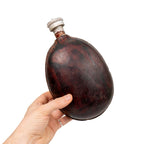 Hand holding WW2 Bulgarian Army coconut canteen demonstrating compact field size