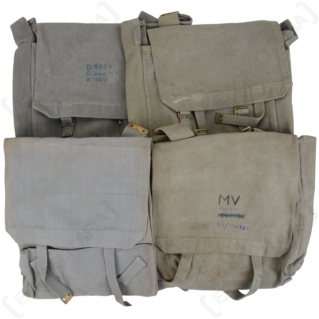 Four 1950s British 37 Pattern Large Packs in RAF grey, highlighting unique stains, wear, and handwritten identification marks.