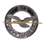 Reverse side of the ATC cap badge showing the copper dual shank loops and brass split pin