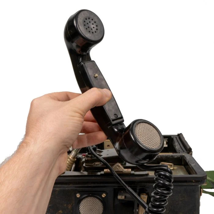 Bakelite telephone handset with coiled cord held in hand