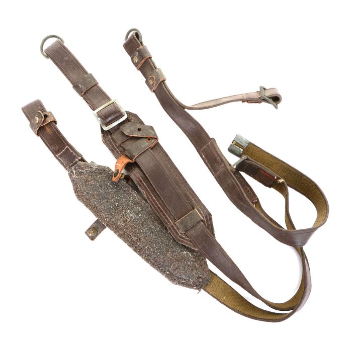 Folded Soviet military Y-strap suspenders showing metal friction buckles and canvas webbing