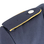 Angled detail of yellow-piped air force shoulder strap on navy blue coat