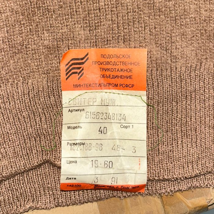 Original orange Cyrillic paper manufacturer tag from Podolsk Knitting Factory dated March 1991 on the Soviet jumper.