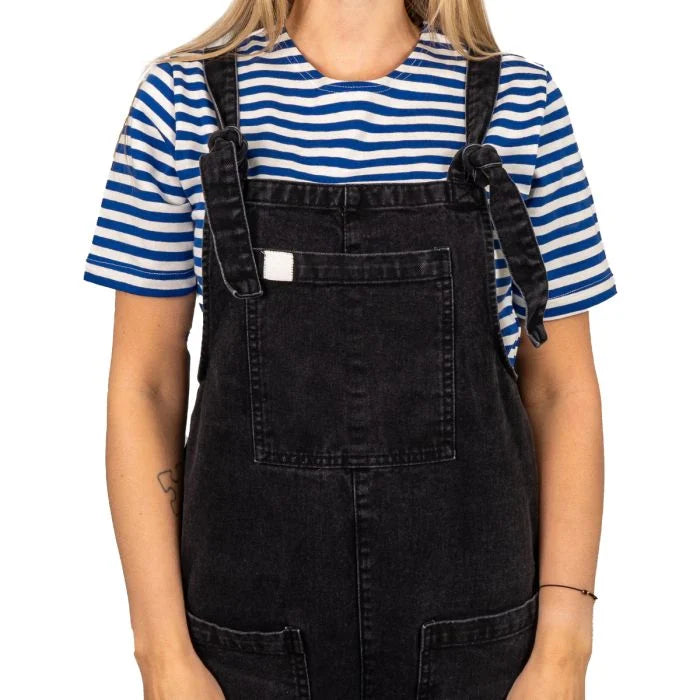 Female model wearing Russian Telnyashka striped short sleeve t-shirt under black denim dungarees