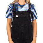 Female model wearing Russian Telnyashka striped short sleeve t-shirt under black denim dungarees