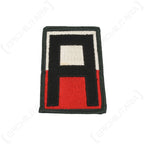Front view of original US First Army shoulder patch featuring black letter A on red and white background