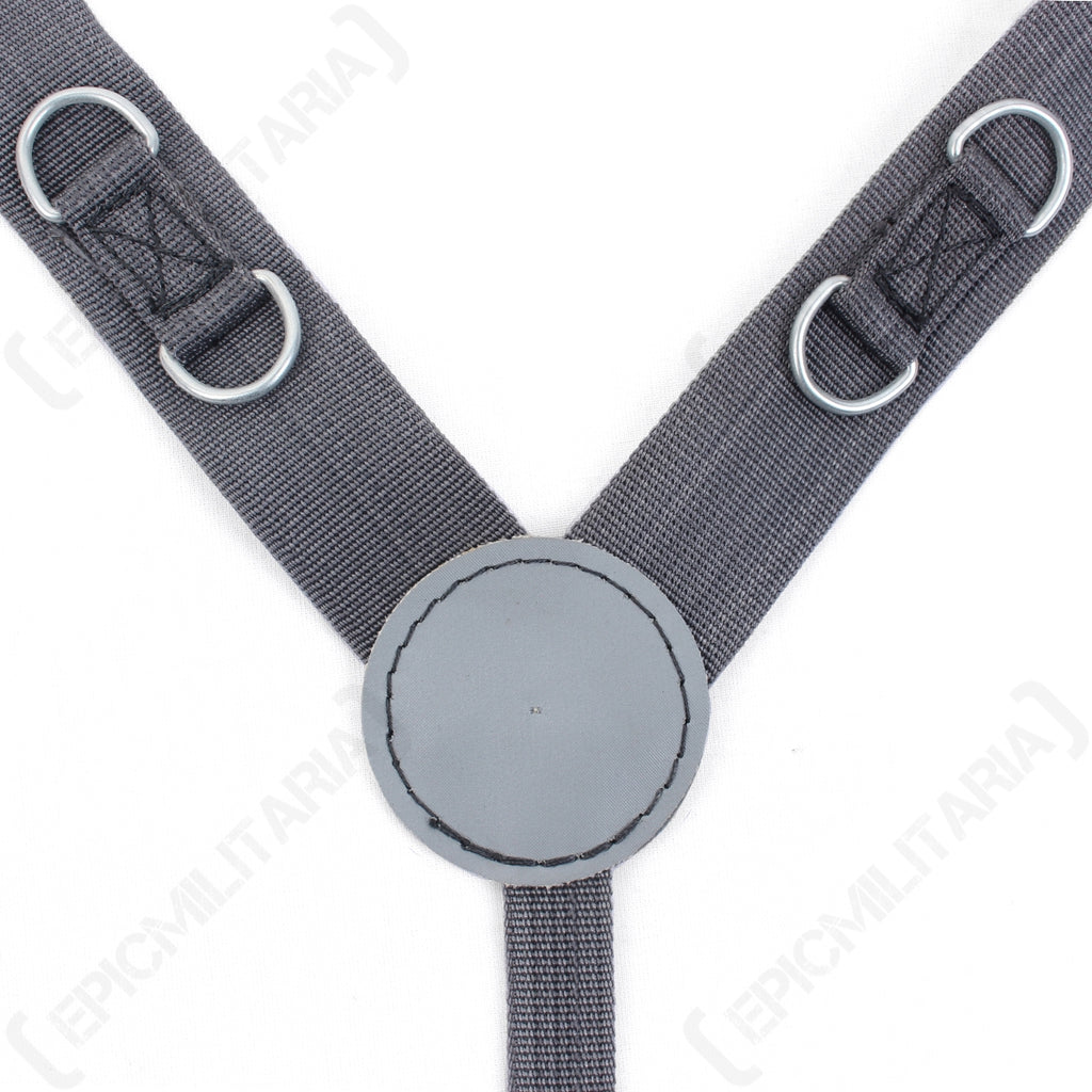 Close-up of East German Y-strap harness showing the central round vinyl back divider, reinforced stitching, and integrated metal D-rings on grey nylon webbing.