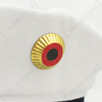 Close-up detail of the traditional German cockade badge in gold, red, and black on the white top cover of the sailor hat.