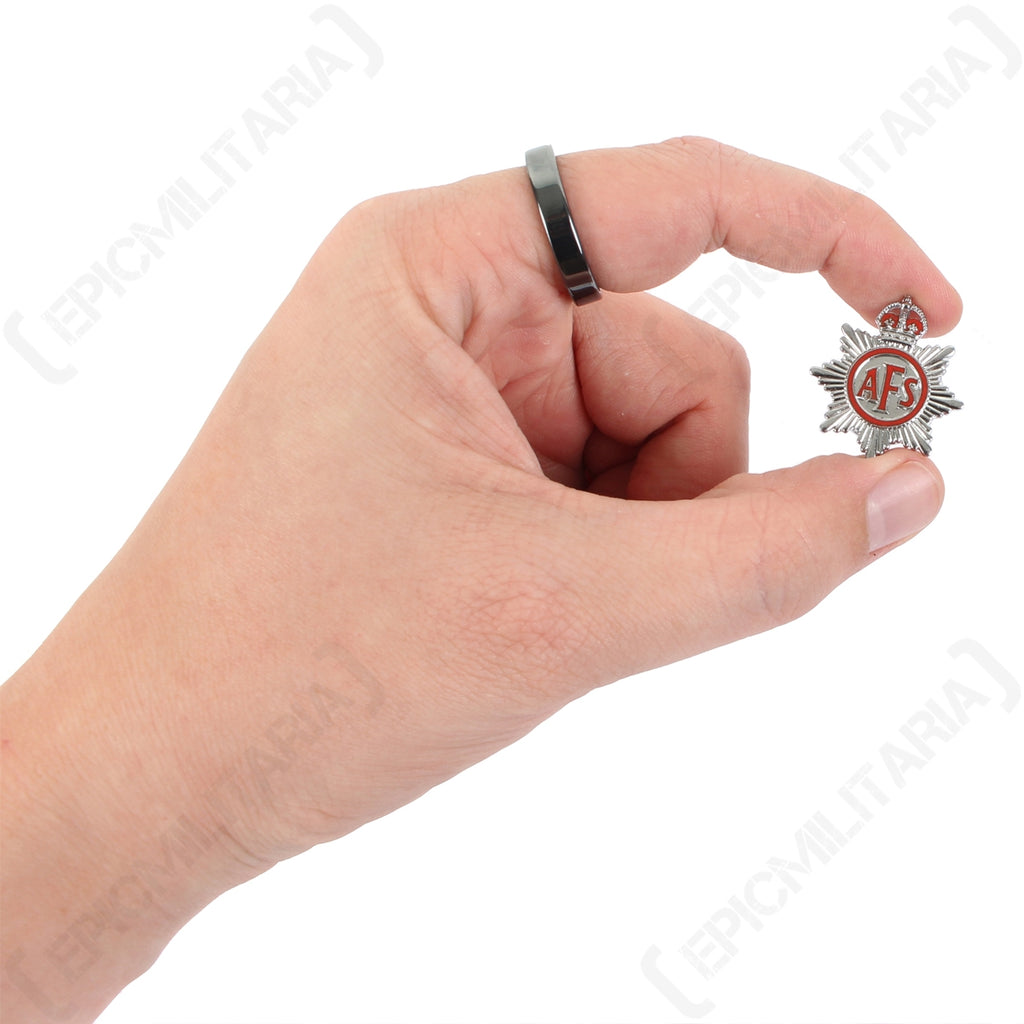 Hand holding a WW2 Auxiliary Fire Service lapel badge for scale, showing its compact size and detailed King's Crown emblem.