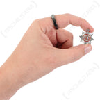 Hand holding a WW2 Auxiliary Fire Service lapel badge for scale, showing its compact size and detailed King's Crown emblem.