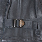 Macro shot of the adjustable wrist strap and metal buckle on the black leather Belgian Army military surplus gloves.