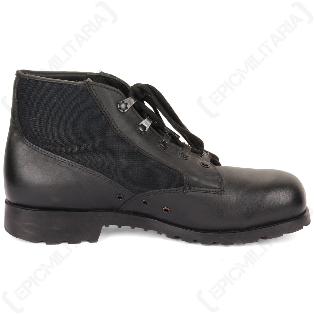 Side profile of a German Navy deck shoe, highlighting the durable black leather upper, breathable canvas panels, and side eyelet ventilation.