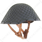 Close-up side view of an East German military helmet equipped with an original olive drab NVA camouflage net and leather chin strap.