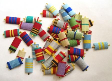 A pile of genuine Soviet and Russian army medal ribbons featuring vibrant, multi-colored woven fabric bars, historical military awards for collectors.