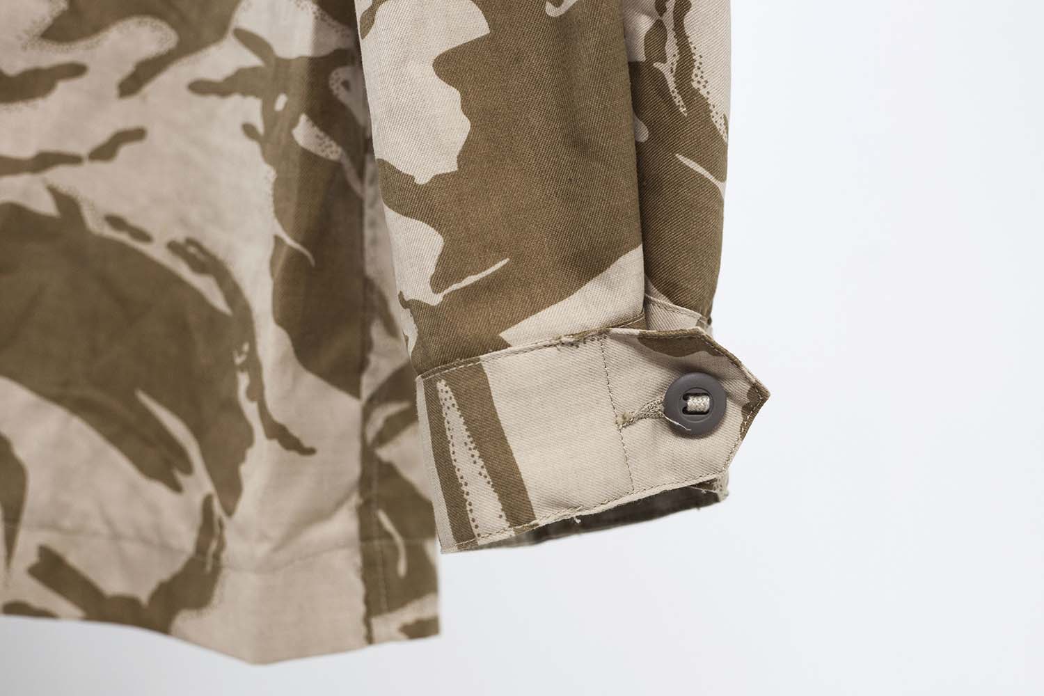 Detail of the buttoned cuff on the long sleeve of the British desert DPM combat field shirt.