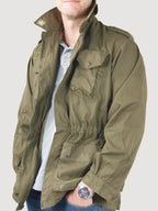 Side profile of genuine Italian army olive green field jacket showcasing the elasticated waist and front pockets