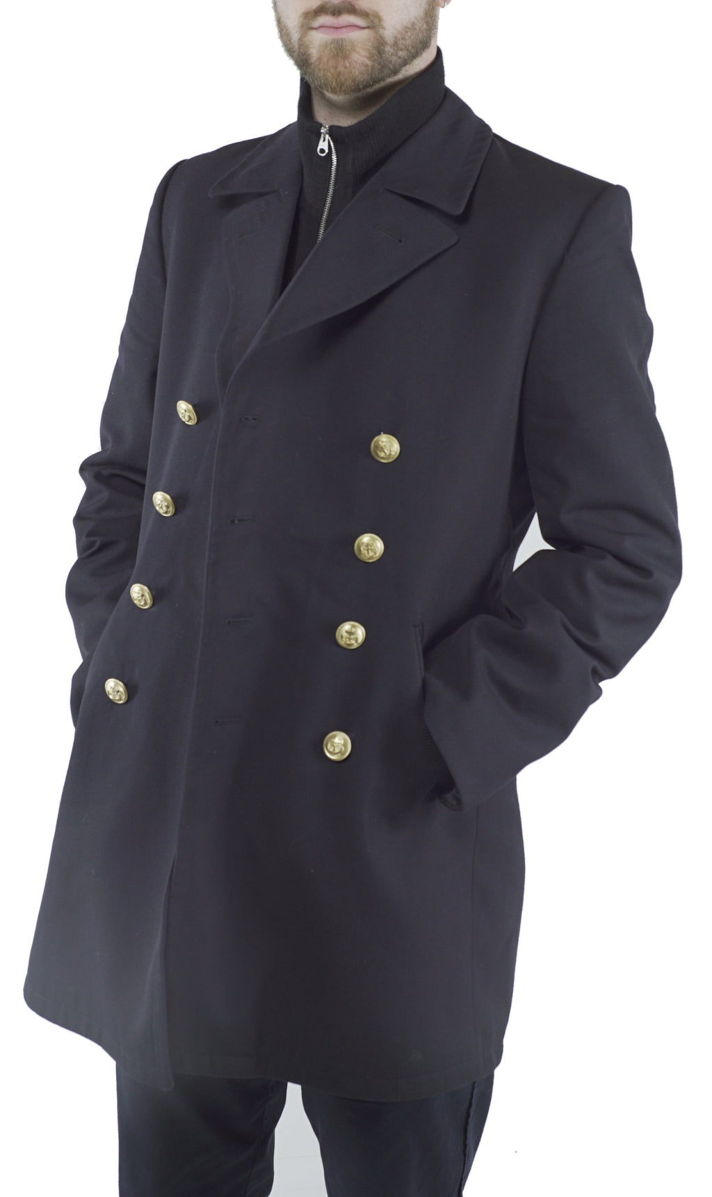 Man wearing a black German Navy gabardine peacoat with anchor emblem double-breasted gold buttons and hands in pockets.