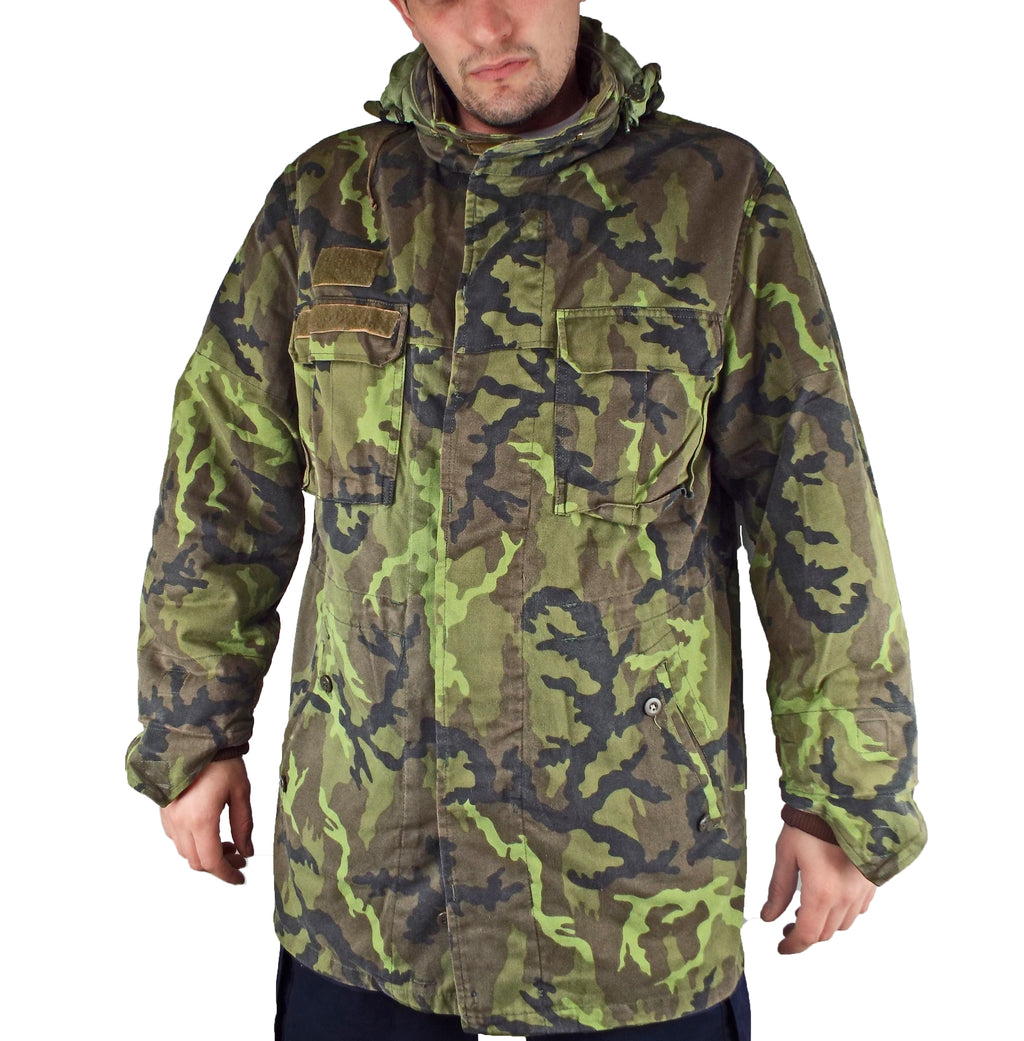 Model wearing a Czech Army M95 camo parka with the classic vz. 95 leaf pattern, front view showing utility pockets.