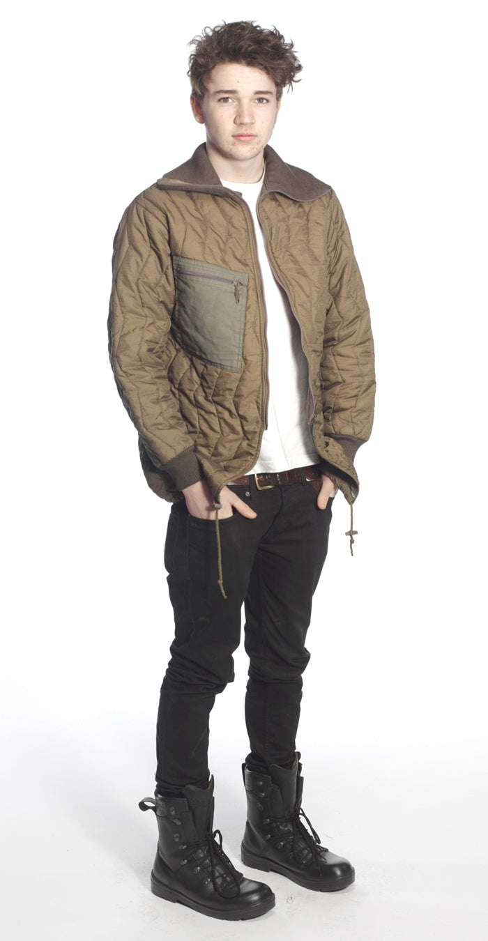 Model wearing the olive green quilted thermal parka liner over casual clothes, demonstrating the fit of the removable Bundeswehr inner jacket layer.