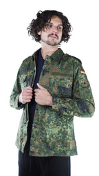 Man displaying the front zipper and button closure details of an authentic vintage German army flecktarn camouflage shirt.