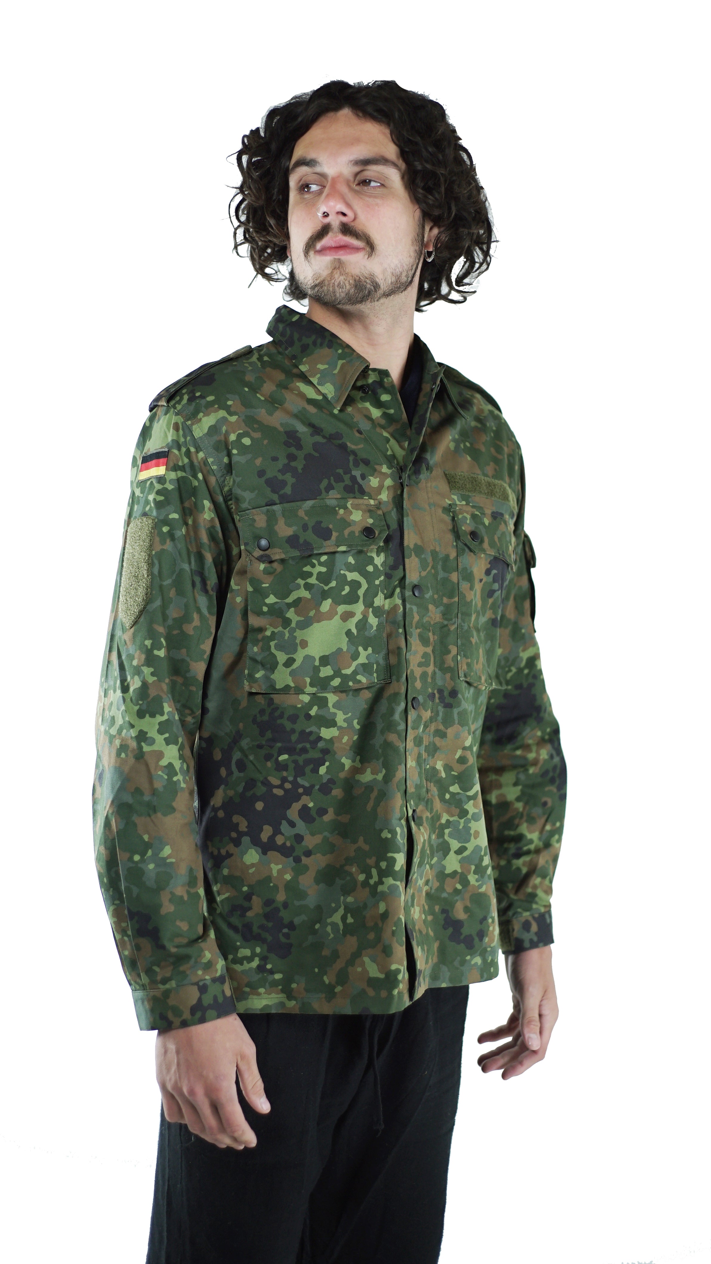 Man modeling a vintage German army flecktarn camo shirt, side view showing the sleeve pocket and German flag patch detail.