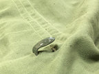 Close-up of the metal combat utility belt hook integrated into the waist of the Bulgarian fatigue shirt.