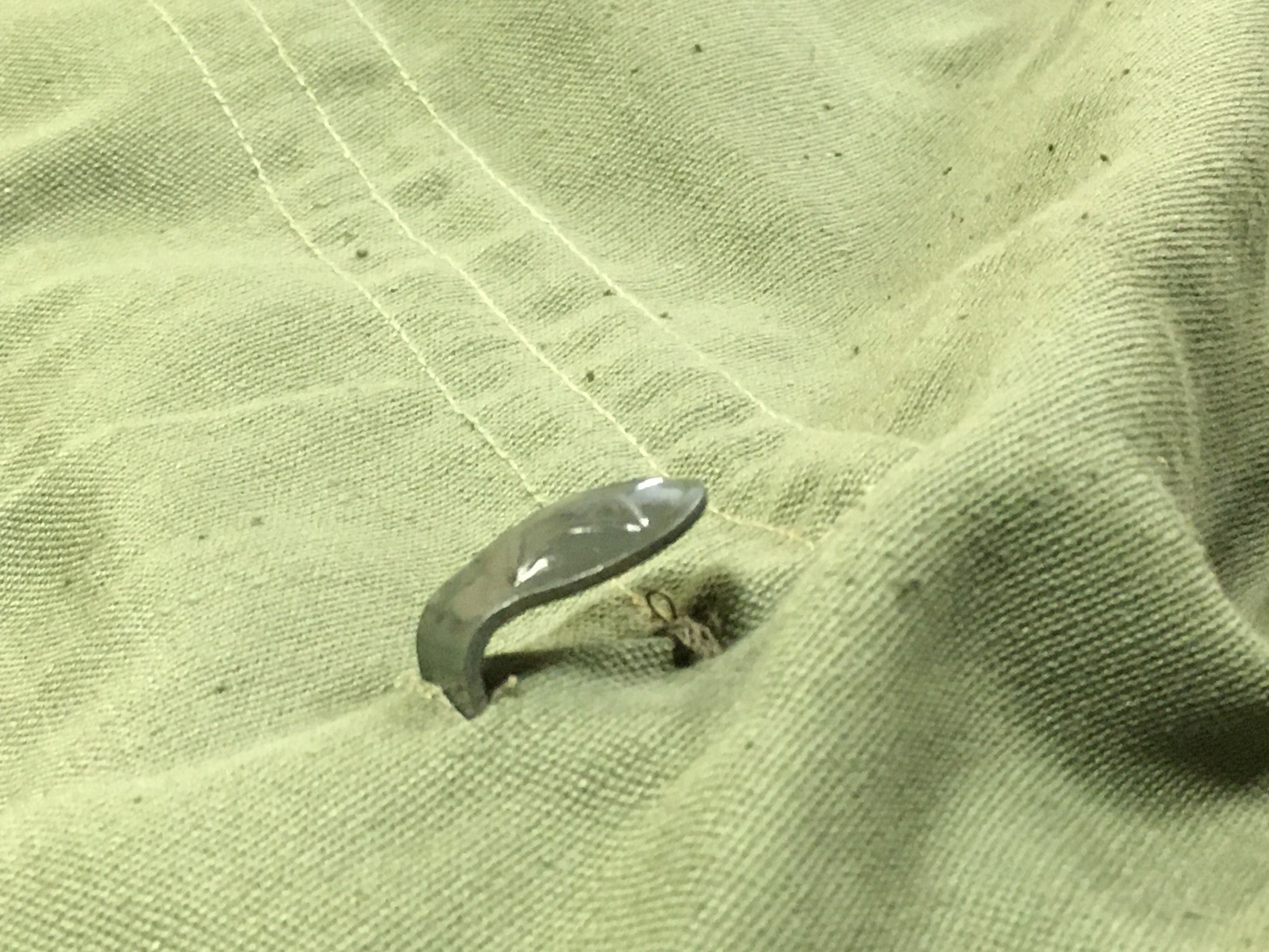 Close-up of the metal combat utility belt hook integrated into the waist of the Bulgarian fatigue shirt.