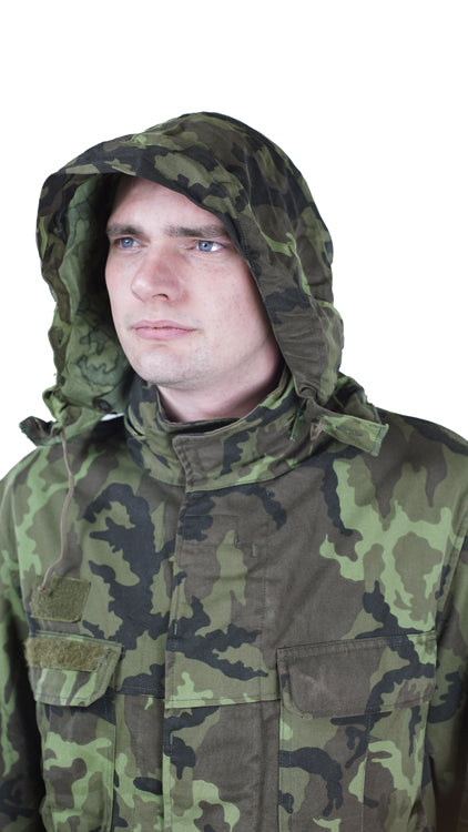 Close-up of a model wearing the Czech Army M95 parka with the concealed hood fully deployed for rain or wind protection.