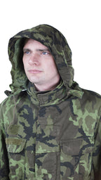 Close-up of a model wearing the Czech Army M95 parka with the concealed hood fully deployed for rain or wind protection.