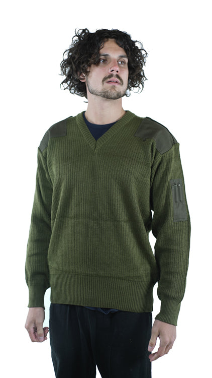 Front view of a man wearing a genuine unissued Italian Army olive green wool jumper featuring a V-neck, shoulder epaulettes, and reinforced arm pen pockets.