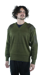 Front view of a man wearing a genuine unissued Italian Army olive green wool jumper featuring a V-neck, shoulder epaulettes, and reinforced arm pen pockets.