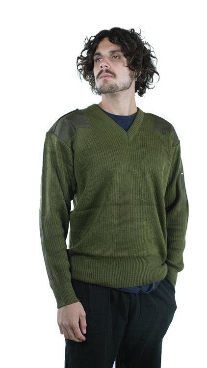 Side profile of a man modeling an unissued Italian military wool pullover, highlighting the olive green rib-knit texture and durable reinforced shoulder and elbow patches.
